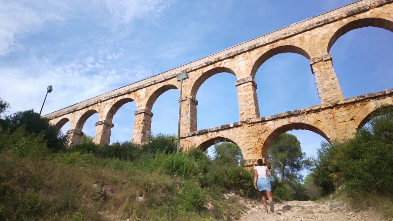 Femme marchant sous l'ancien aqueduc romain de Tarragone