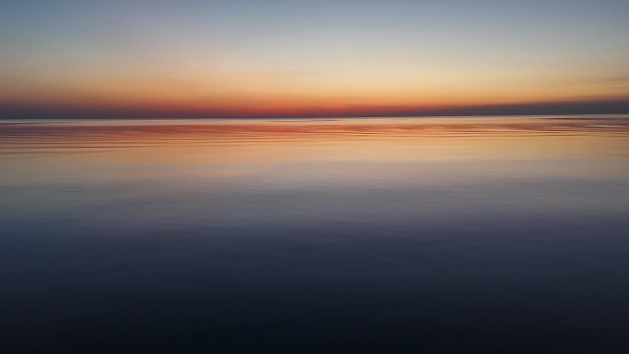 drone disparado sobre la superficie de un lago tranquilo al atardecer