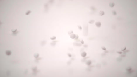 Slow-Motion-Macro-of-White-Pills-Dropped-onto-White-Background