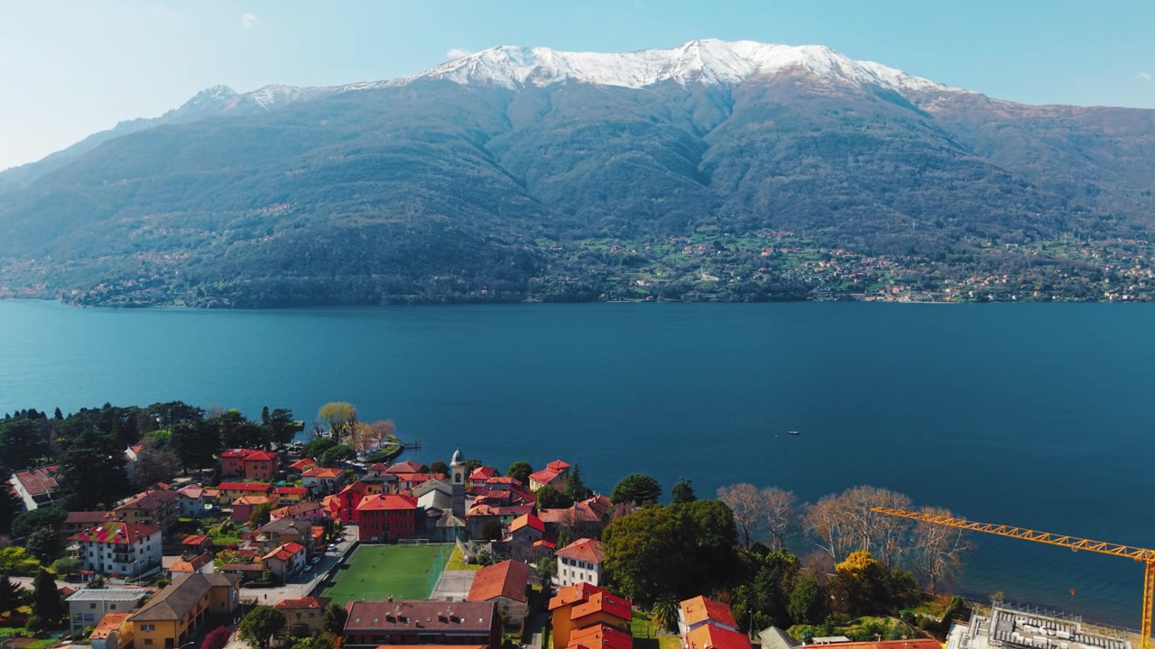 Paesaggio panoramico del Lago di Como con cime alpine e acqua azzurra.