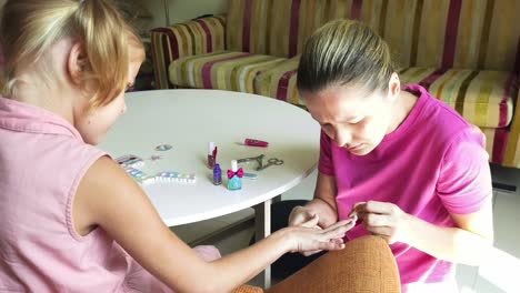 mother and daughter doing manicure at home