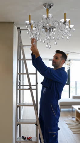 man installing or repairing a chandelier in a home