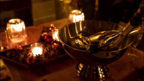 champagne bottles at decorated christmas table on with tea lights, ready for holiday celebrations