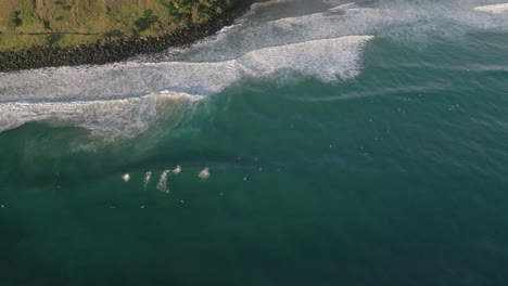 Aerial-views-over-surfers-at-Burleigh-Heads-at-sunrise,-Gold-Coast,-Queensland,-Australia