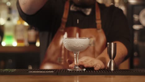 bartender preparing a blue cocktail at a bar