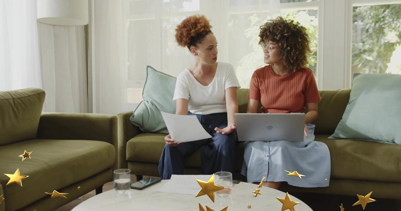 Two women picking docs reading aloud, pausing laptop and clarifying project points with stars