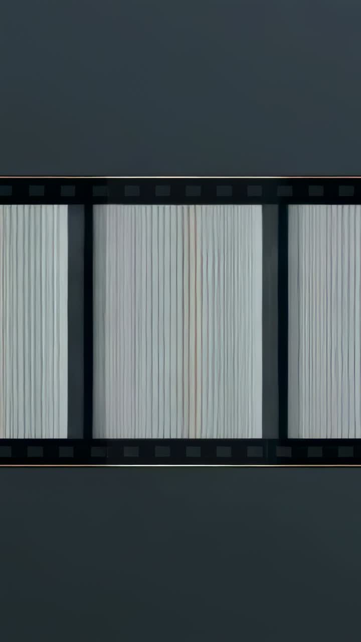 Vertical video: Starting playback, filmstrip scanning across dark gray plane with frames, sprockets