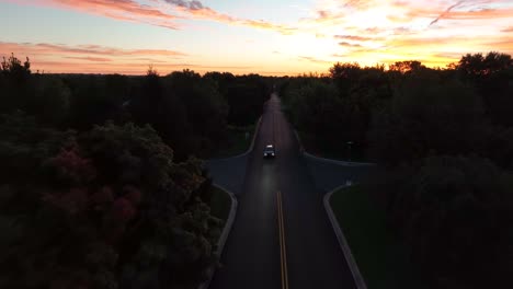 Aerial-dolly-forward-over-American-street-during-beautiful-orange-sunrise