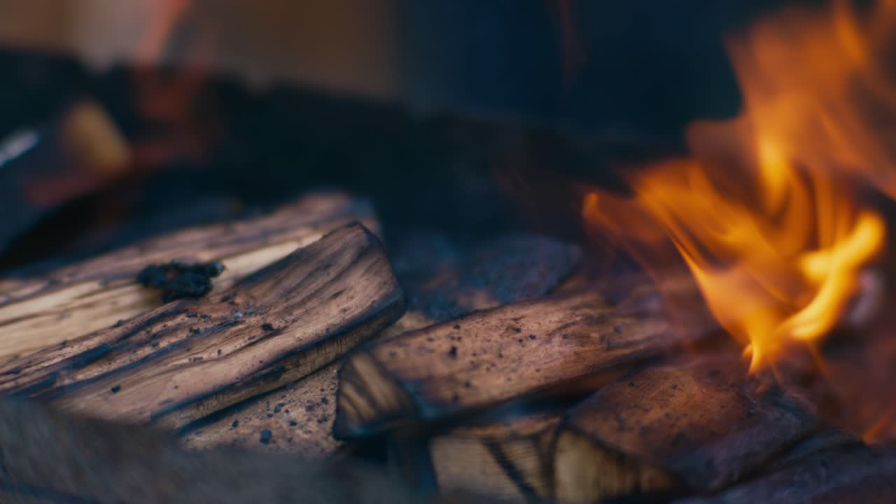cerca de la madera ardiente con llamas y humo macro de mano