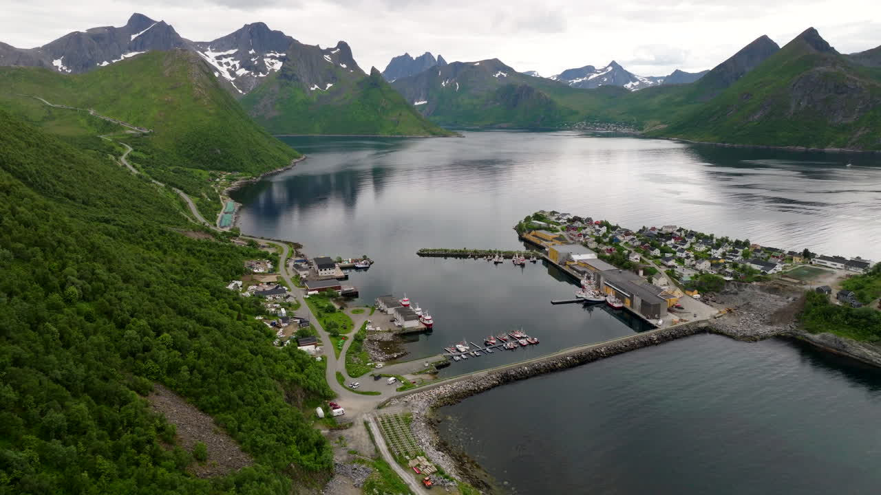 Aerial drone view of Husøy, fishing village on island in Øyfjorden, Senja, mountains and arctic landscape in northern Norway