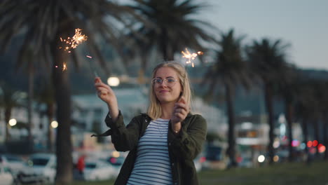 Junge-Frau-Tanzt-Mit-Wunderkerzen-Am-Strand-Bei-Sonnenuntergang-Und-Feiert-Silvester,-Feiert-Den-Unabhängigkeitstag-Mit-Feuerwerk-Und-Genießt-Die-Freiheit