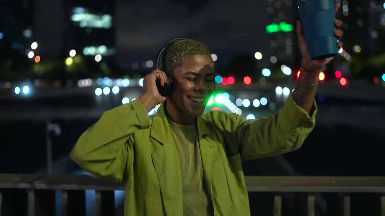 Woman with headphones dancing at night