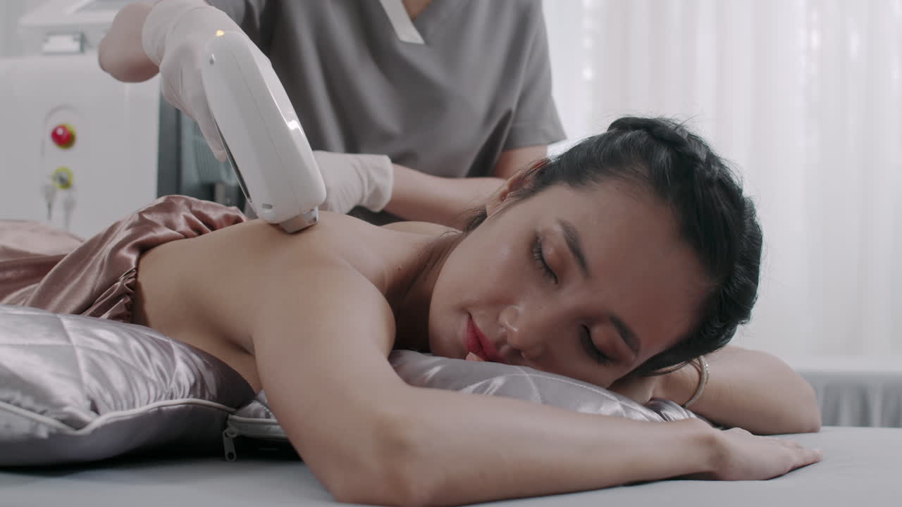 Beautician Giving Back Laser Treatment to Female Client