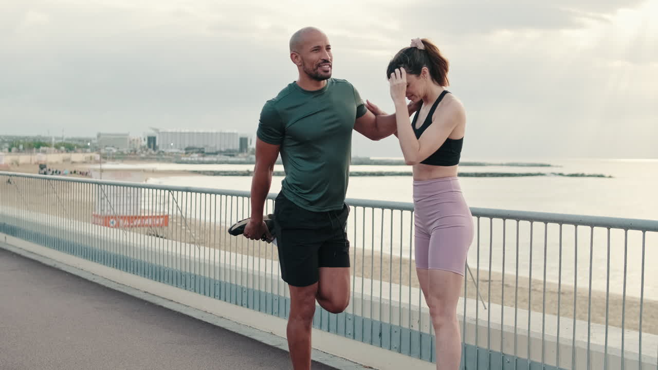 Athletic Couple Stretching on a Seaside Promenade