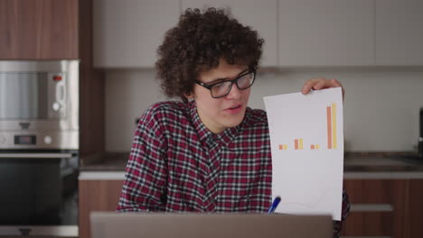 a man shows a graph in a web camera