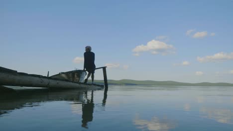 person on a wooden dock by a lake