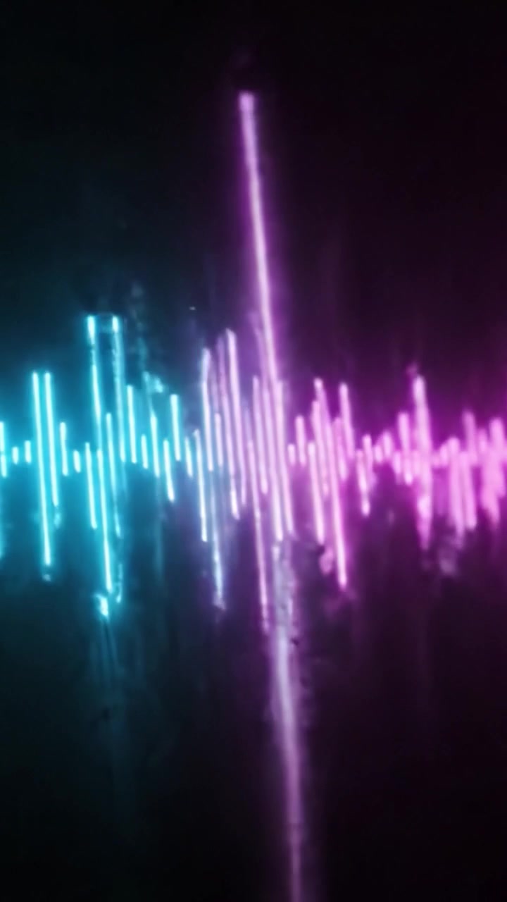 Dynamisk visuel repræsentation af lydbølger i levende blå og lyserøde nuancer, der viser lydfrekvensmønstre og rytmisk flow i et mørkt miljø.