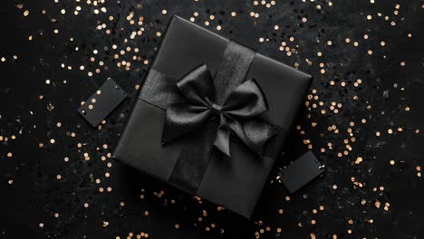 elegante caja de regalo negra con cinta y decoración de confeti