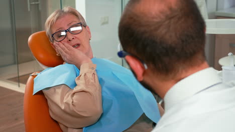 client touching face having toothache at stomatology clinic