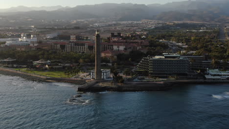 Toma-Aérea-Del-Resort-De-Gran-Canaria-En-La-Costa-Y-El-Faro-De-Maspalomas-Por-La-Noche