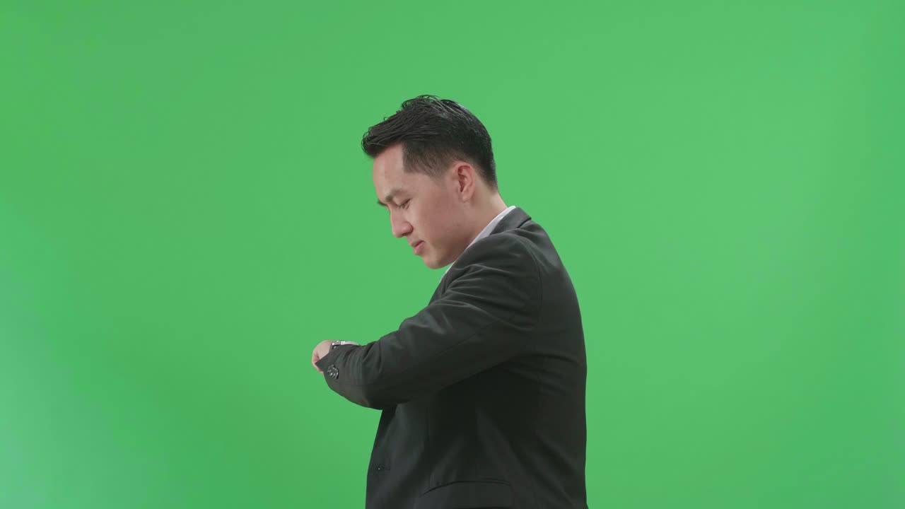Side View Of Asian Business Man Walking And Looking At Watch On Green Screen Chroma Key