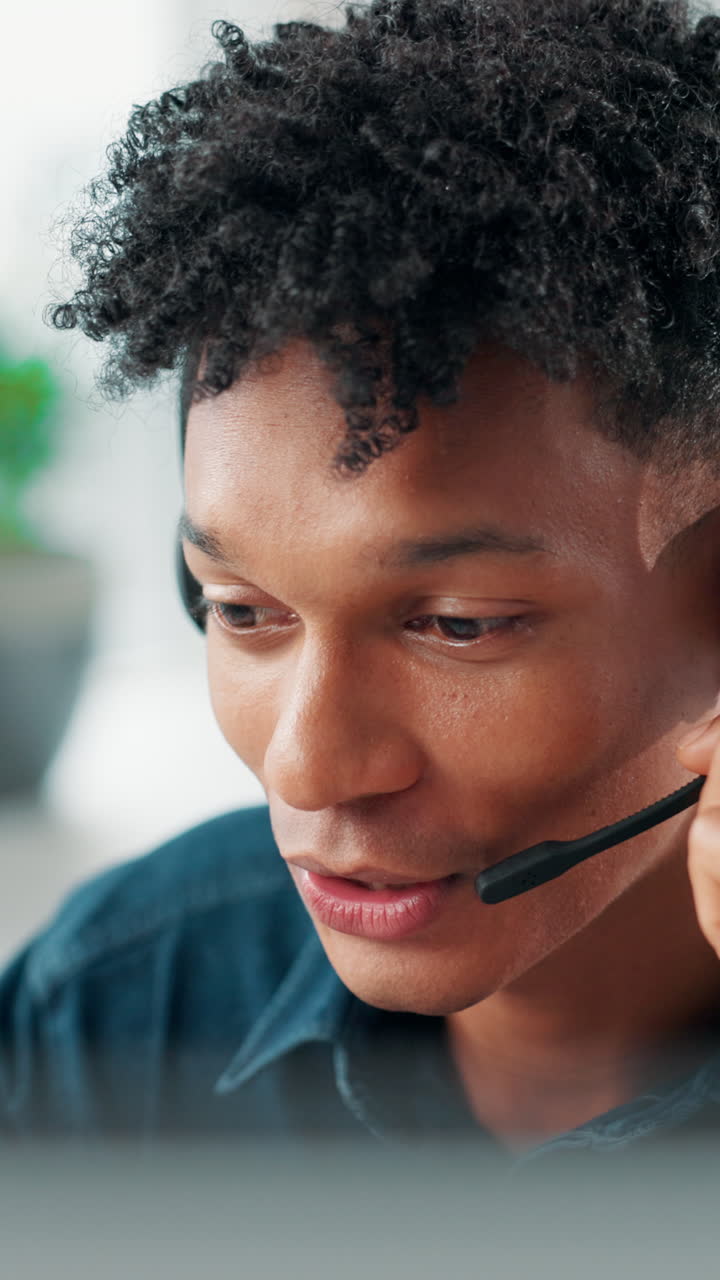 Giovane uomo con cuffie che parla in un call center
