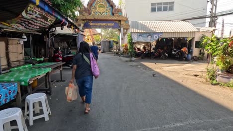 a person walking down a lively market alley.