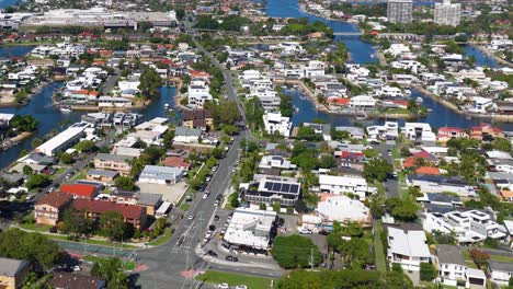 aerial footage of gold coast, australia, showcasing residential areas, waterways, and greenery under bright daylight