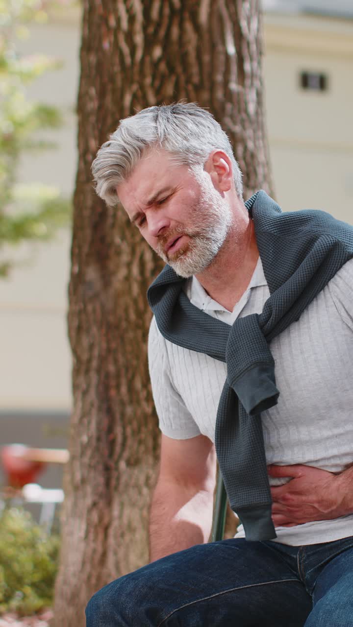 Mature man feeling sudden strong abdominal stomach ache gastritis problem poisoning diarrhea outdoor