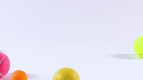 a dynamic display of colorful balls scattered across a white background, showcasing variety and playful arrangement.