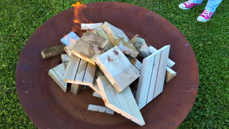 Closeup-view-of-small-pieces-of-wood-getting-burnt-on-a-metal-grill