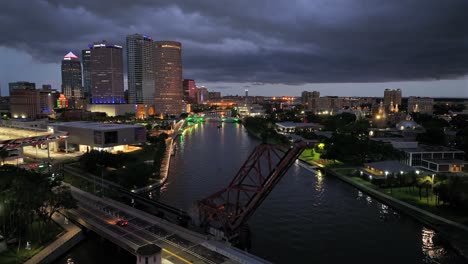 aerial night view of a city skyline with an illuminated drawbridge over a river
