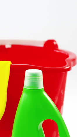 cubo de plástico con guante y detergente