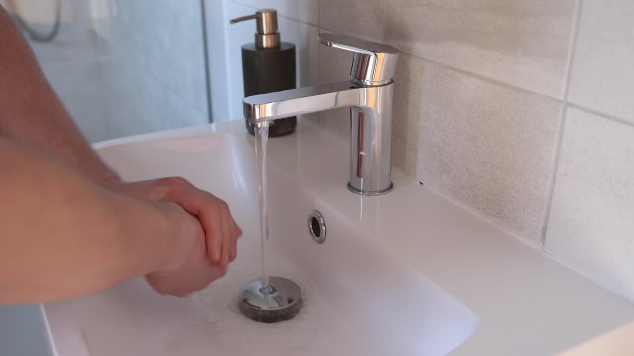 Un uomo che si lava le mani in un lavandino del bagno