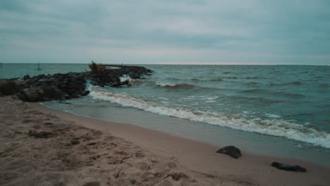 Waves-of-lake-IJsselmeer-crashing-into-the-beach-and-the-cribs