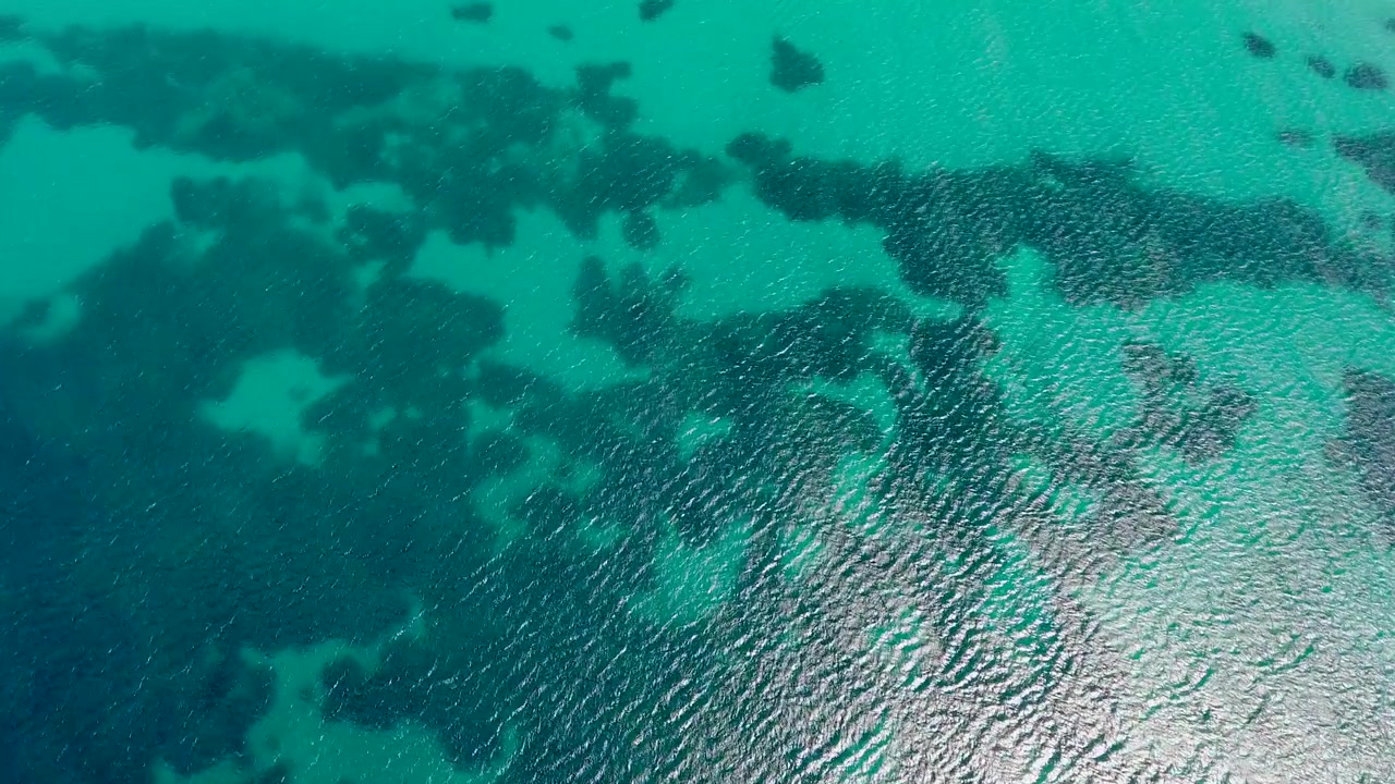 Flygfoto över klart turkost havsvatten med korallrev