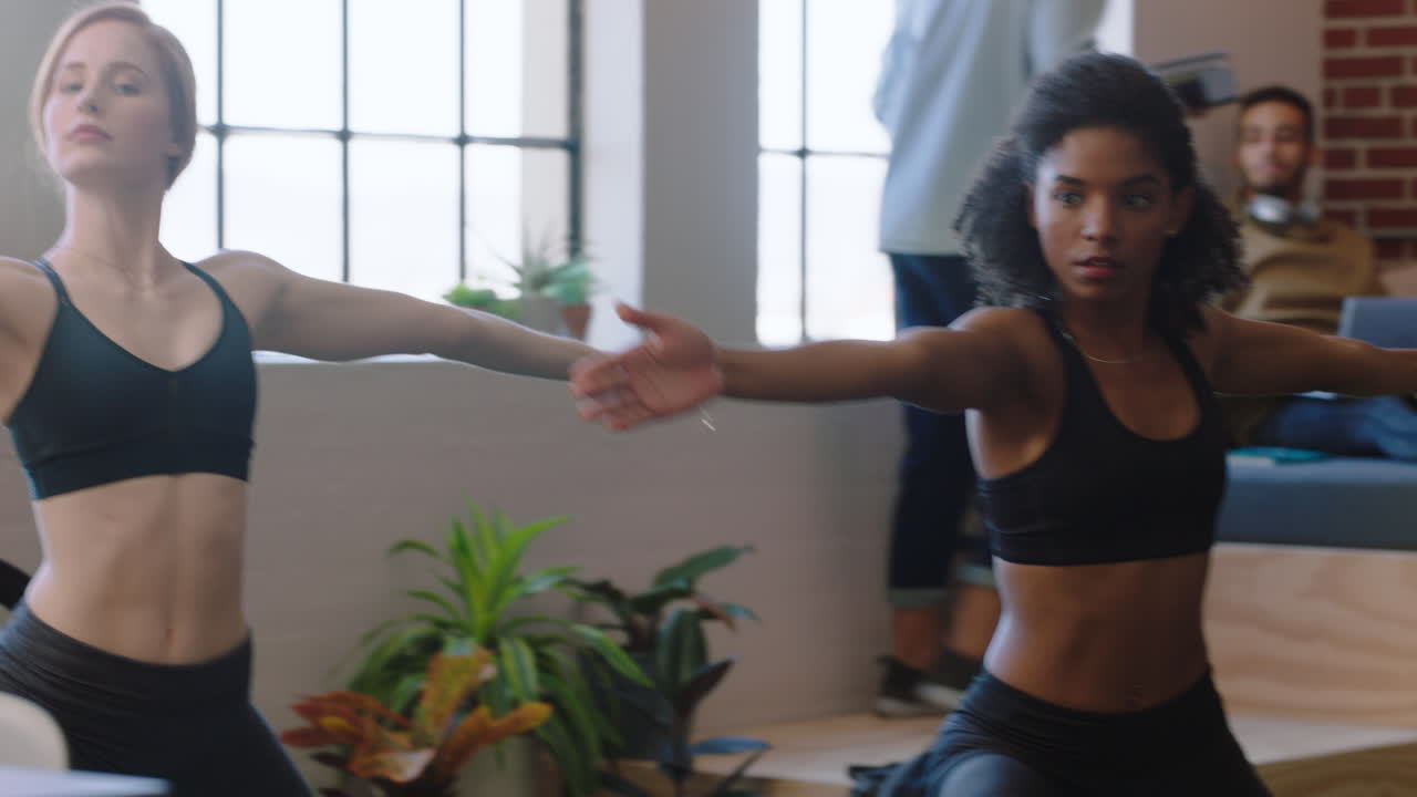 mujeres de negocios jóvenes practican meditación de yoga juntas en diversas oficinas haciendo postura de guerrero disfrutando del ejercicio de atención plena relajándose en la pausa del almuerzo lugar de trabajo creativo de moda