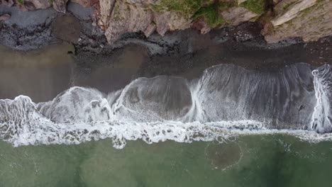 Luftbild-Abschlussaufnahme-Von-Wellen,-Die-An-Einem-Winternachmittag-An-Einem-Kiesstrand-An-Der-Copper-Coast-Waterford,-Irland,-Brechen