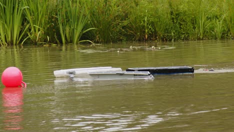 Mehrere-Selbstgebaute-Ferngesteuerte-Solarboote-Fahren-In-Zeitlupe-Durch-Einen-Teich