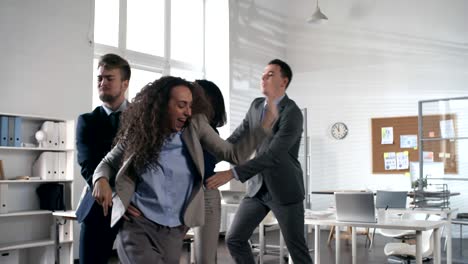 feliz equipo de negocios bailando en conga línea en la oficina