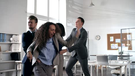 happy business team dancing in conga line in the office