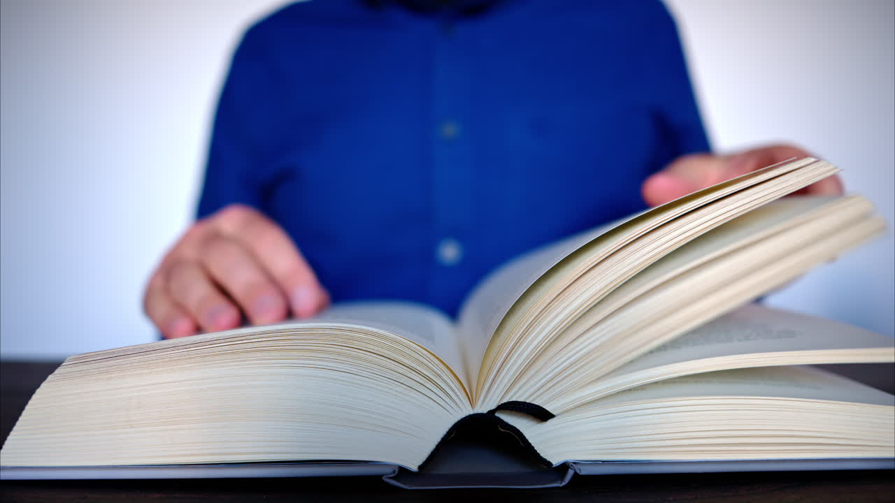 Close-up of a man leafing through a big book