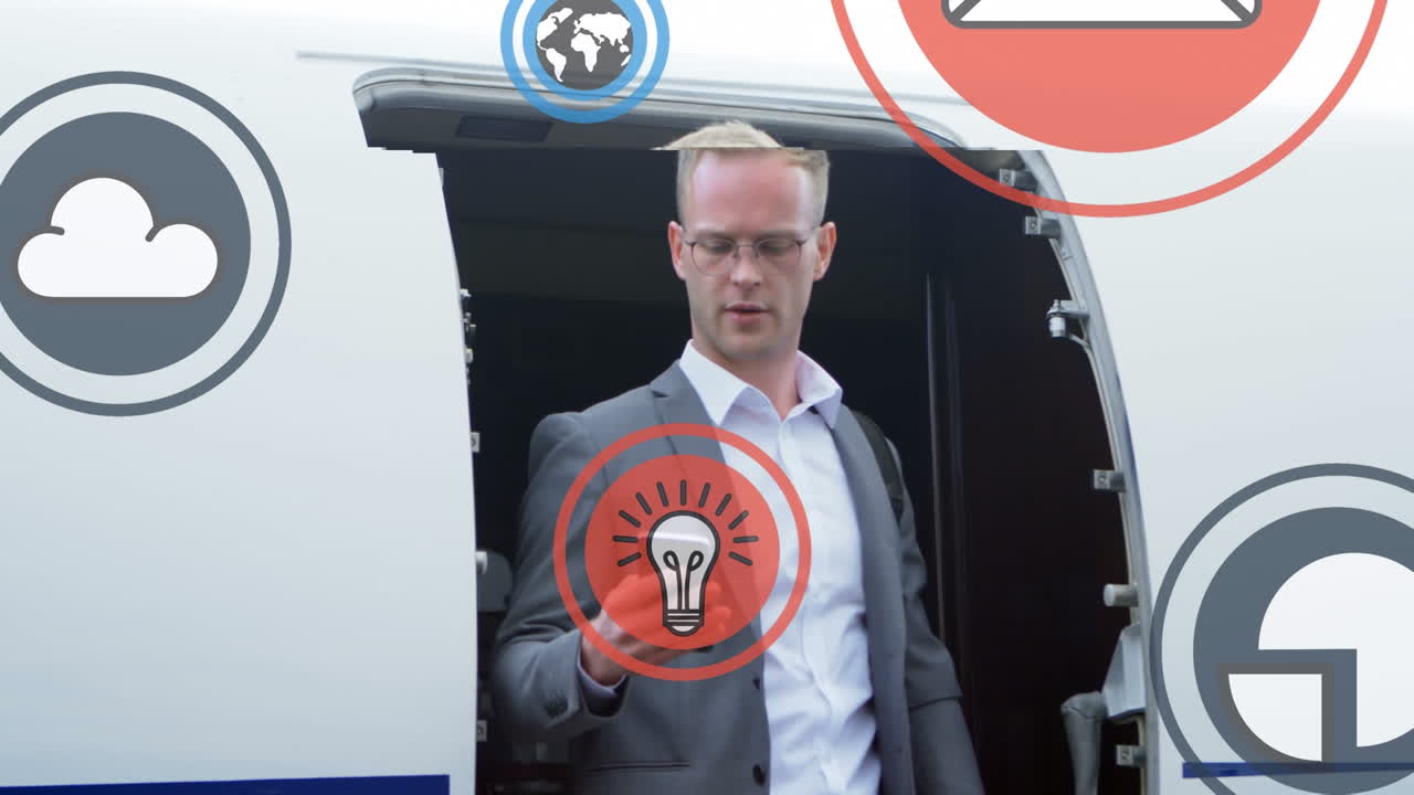 varios iconos digitales sobre un hombre de negocios caucásico usando un teléfono inteligente de pie en el avión