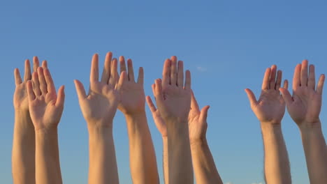 Hands-up-on-blue-sky-background