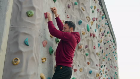 Gemeinsame-Trainingseinheit-Eines-Mannes,-Der-Ohne-Versicherung-Draußen-Eine-Kletterwand-Erklimmt