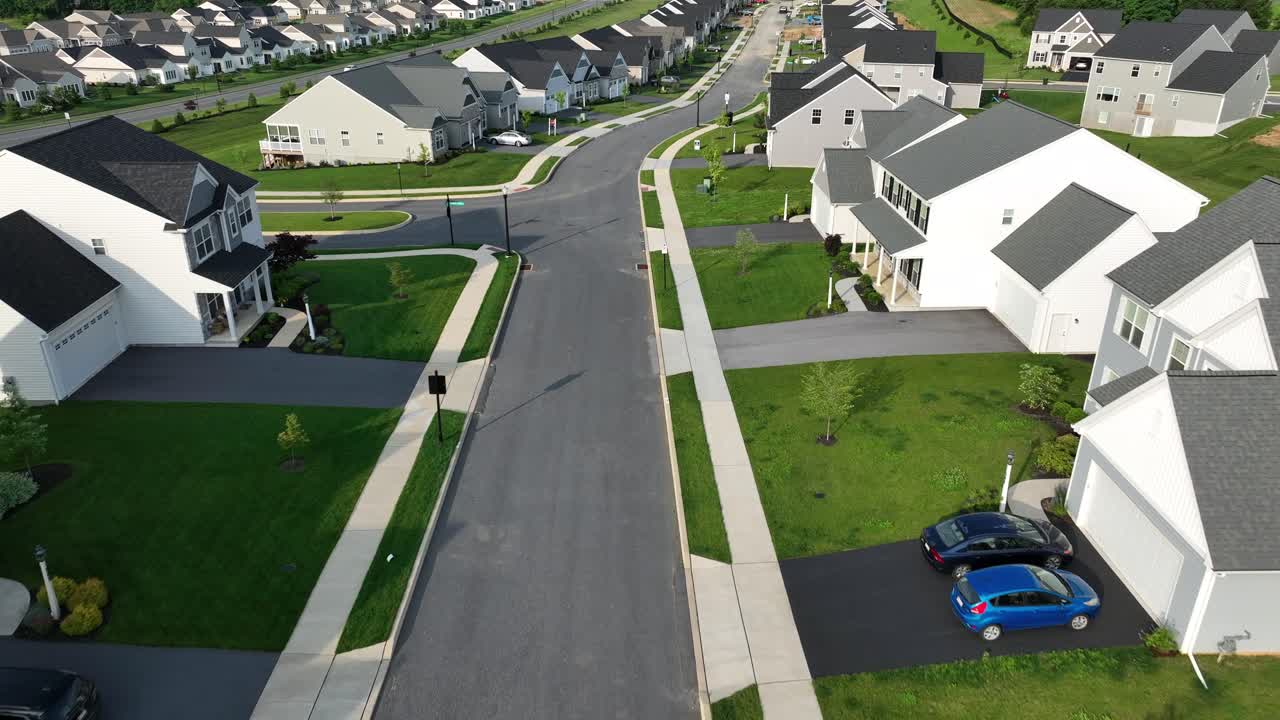 Golden hour in new American suburb town. Aerial Birds Eye shot. Luxury modern houses and homes in upscale neighborhood. Flyover shot