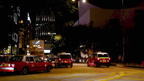 taxis and bus navigate city streets at night