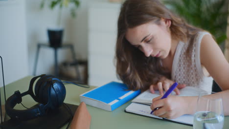 mujer escribiendo y haciendo la tarea en el escritorio