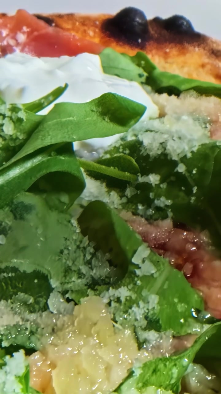 Una deliziosa pizza con spinaci vivaci e ricchi condimenti di formaggio, creando una scena che fa venire l'acquolina in bocca.