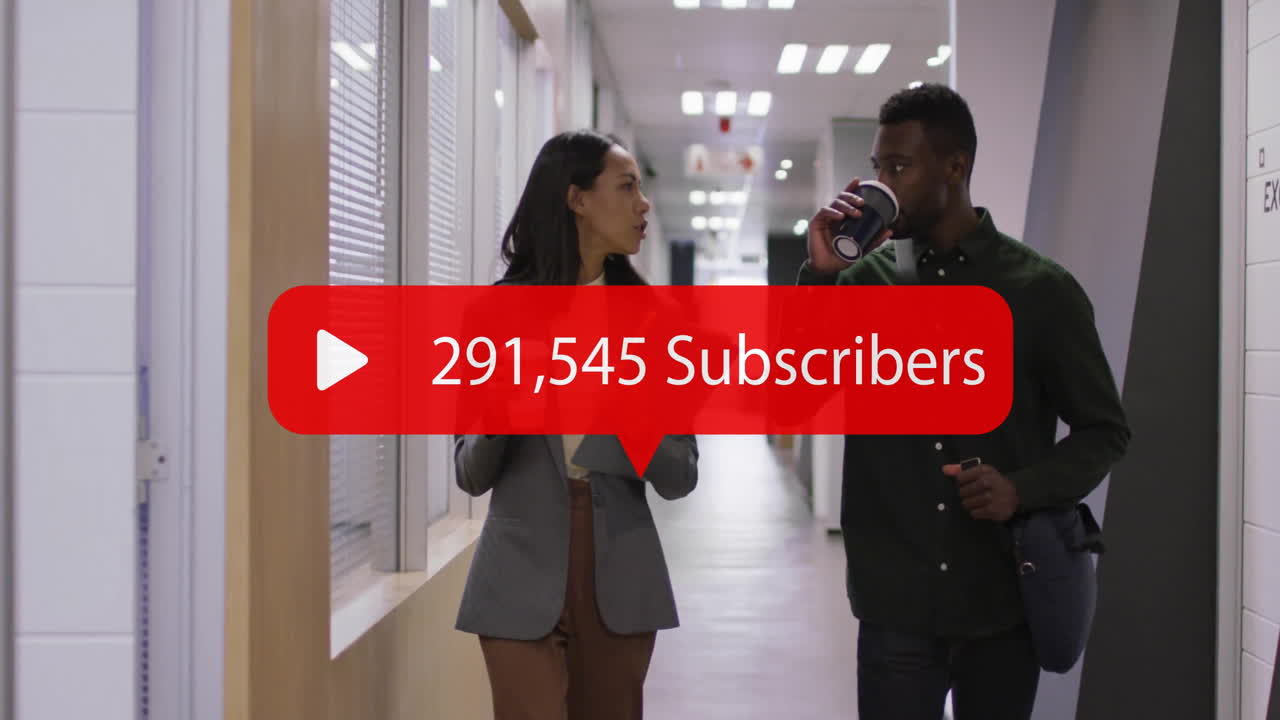 사무실 복도에서 걸어가는 두 동료는 329,020 명의 가입자와 함께 이야기하고 있습니다.